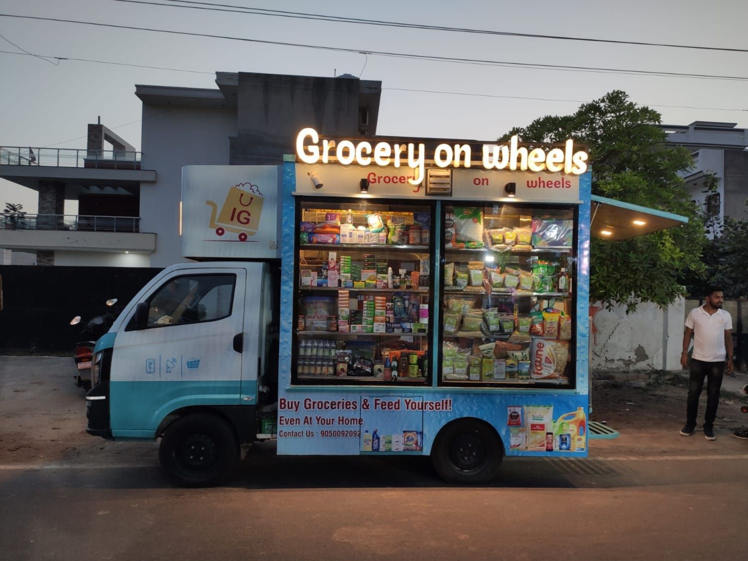 A modern grocery delivery van driving through a city